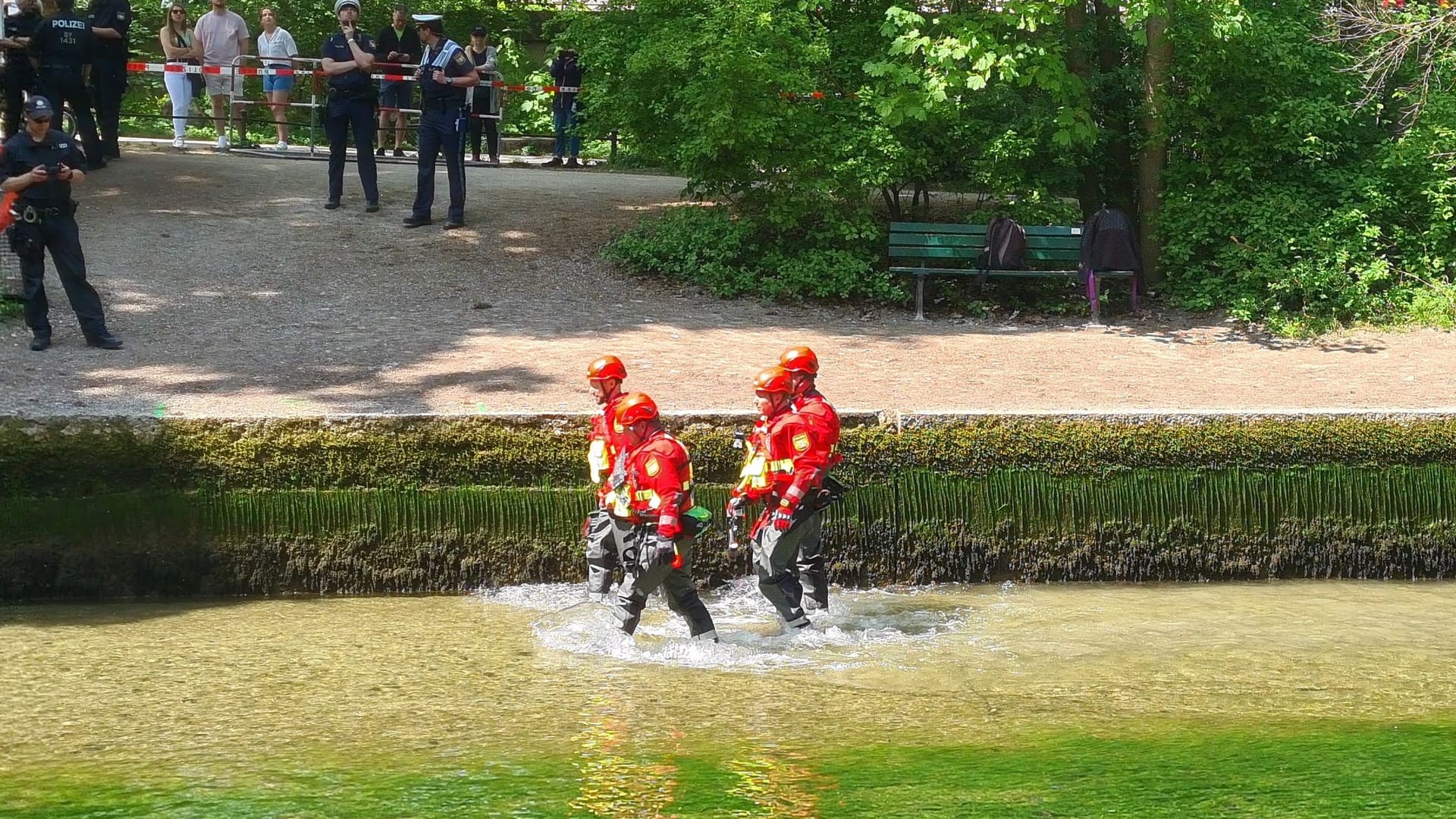 Die Polizeitaucher waten zur Eisbachwelle: Vor dem Einsatz wurde der Wasserstand abgesenkt.