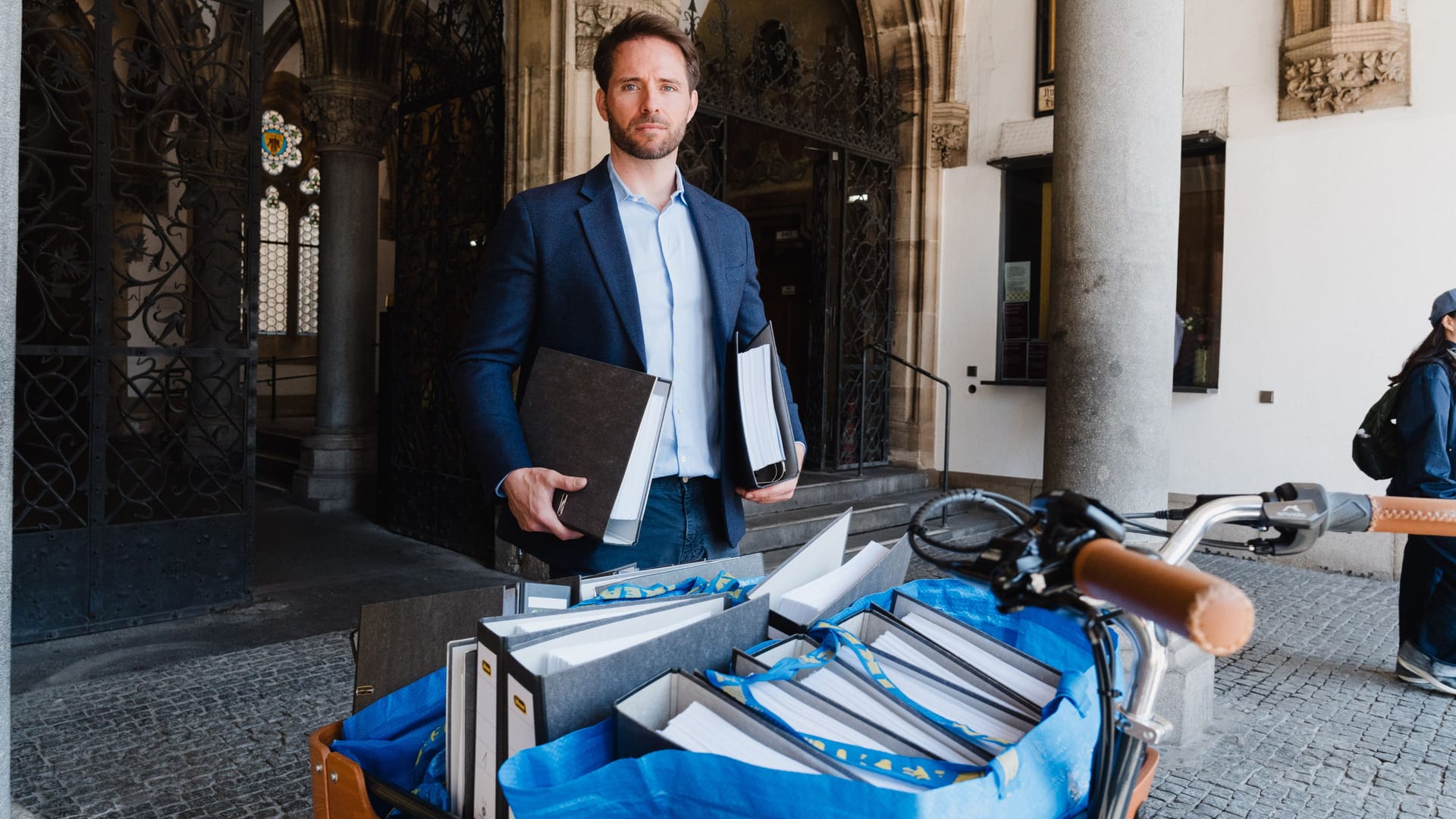 Christoph Weigler, Uber Deutschland-Chef, vor dem Rathaus mit rund 4.500 ausgedruckten Beschwerde-E-Mails, die sich gegen den Mindestpreis richten.