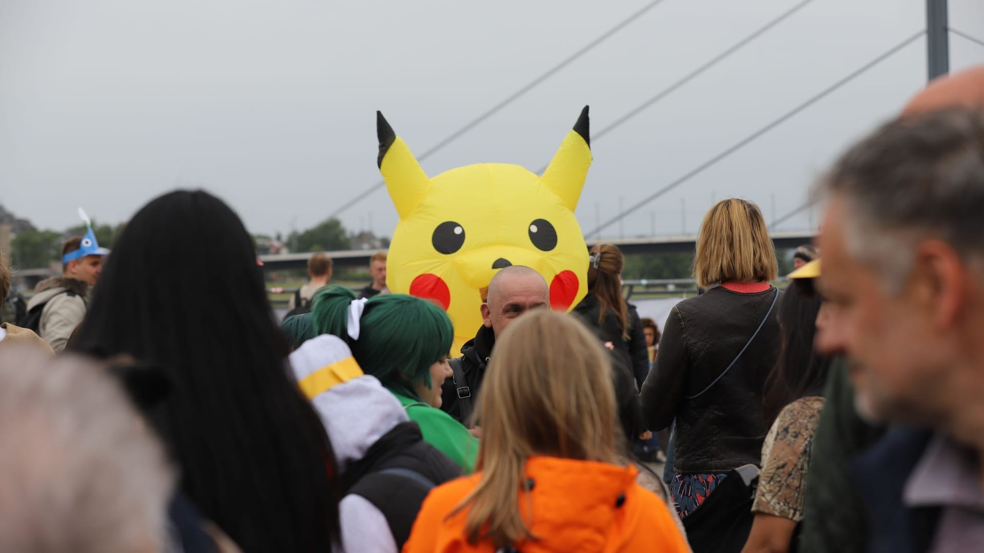 Verkleidete Personen gehen am Rheinufer entlang: Natürlich darf auch das berühmteste Pokémon Pikachu nicht fehlen.