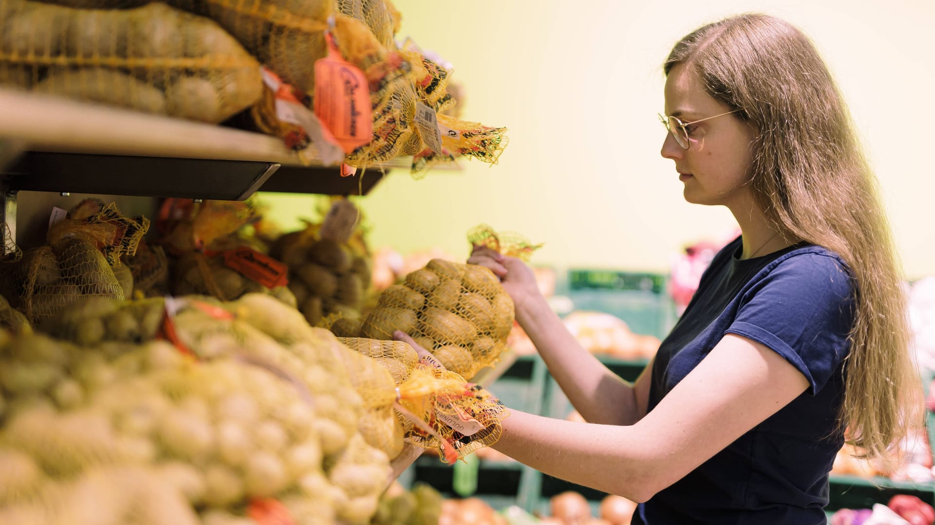 Eine Frau nimmt einen Sack mit Kartoffeln aus einem Supermarktregal (Symbolbild): Der Preis für Kartoffeln stieg in diesem Monat um über 60 Prozent.