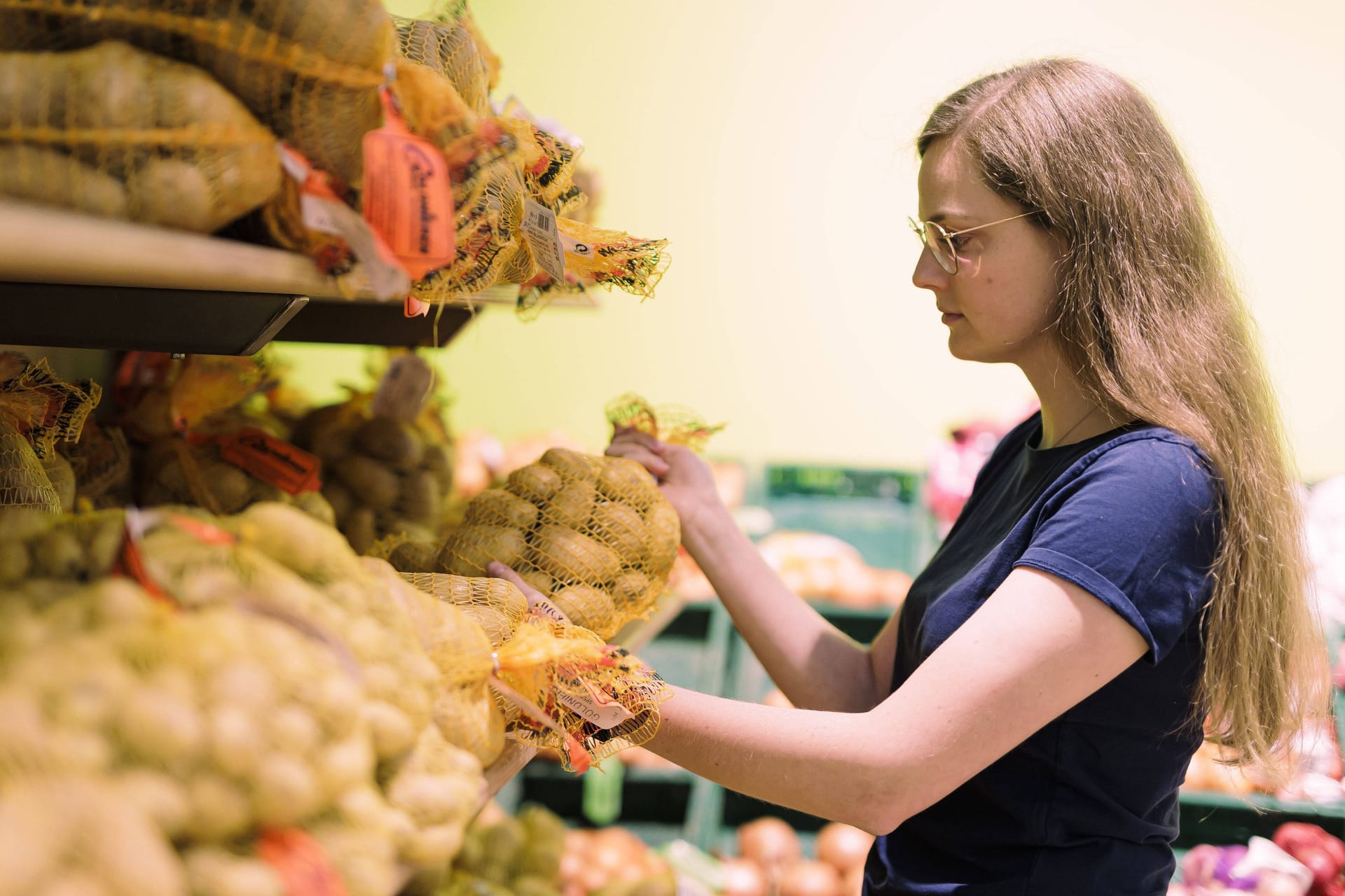 Eine Frau nimmt einen Sack mit Kartoffeln aus einem Supermarktregal (Symbolbild): Der Preis für Kartoffeln stieg in diesem Monat um über 60 Prozent.