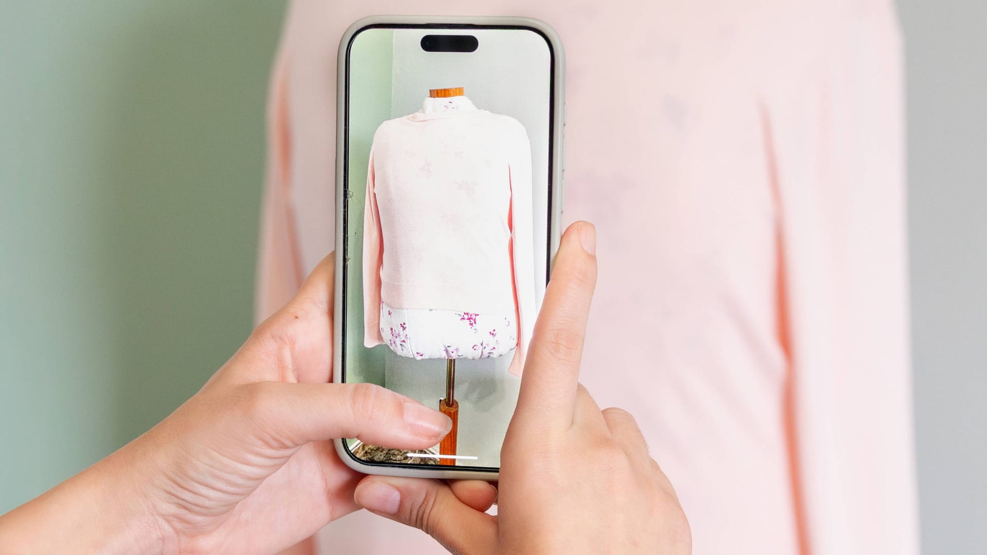 Eine Frau fotografiert einen Pullover auf einem Manequin: Vinteds Erfolg zeigt, wie Secondhand den Modemarkt verändert.