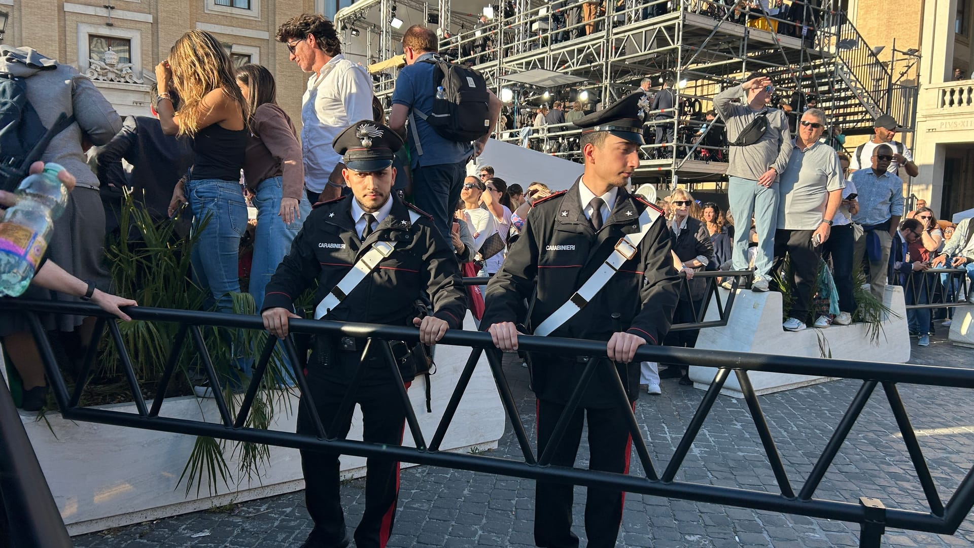 Polizisten sperren einen Fluchtweg ab, Zuschauer steigen währenddessen auf die Absperrungen.