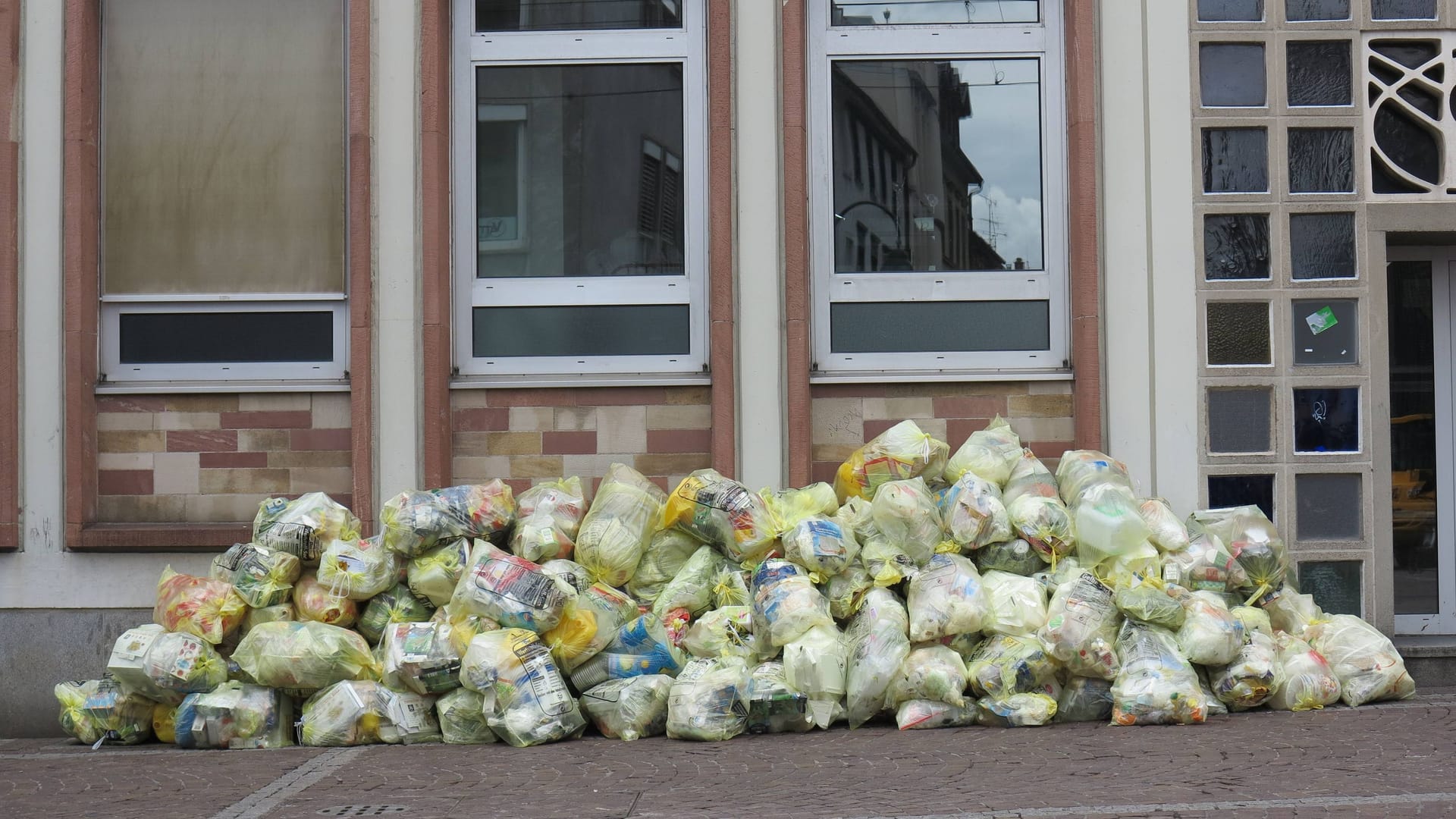 Gelbe Säcke vor einem Haus (Symbolfoto): Noch die ganze Woche müsse mit Einschränkungen zu rechnen sein.