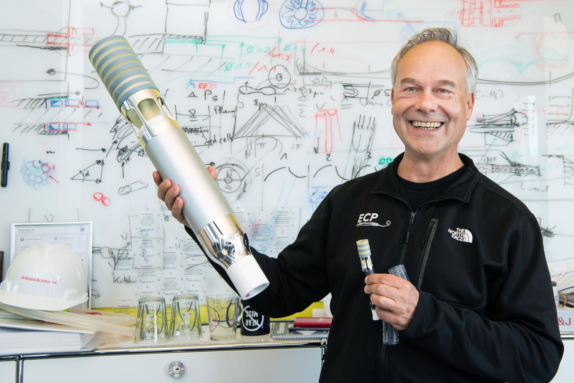 Dr. Thorsten Sieß hält die Herzpumpe in Über- und Miniaturgröße in der Hand: Die Pumpe half hunderttausenden Menschen.