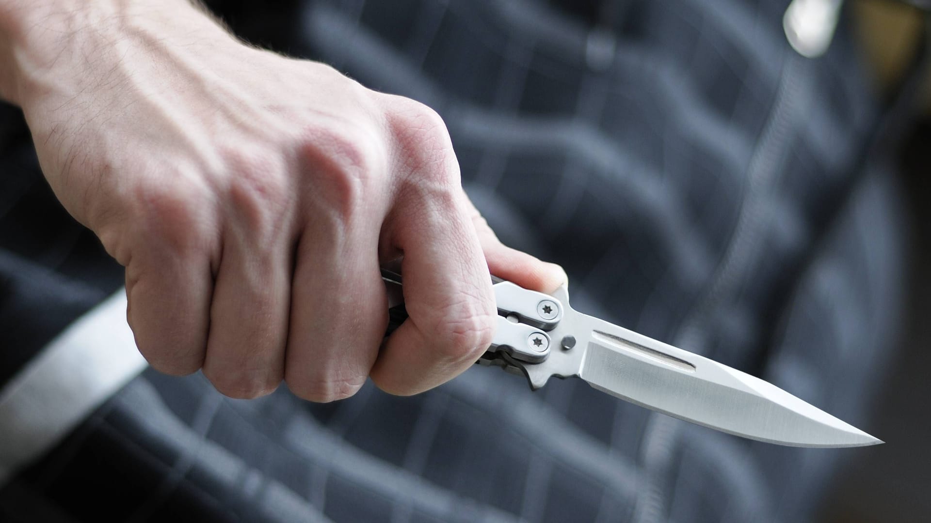 Ein Mann hält ein Butterflymesser: Der Anstieg der Messerkriminalität spiegelt eine Männlichkeitskrise wider.