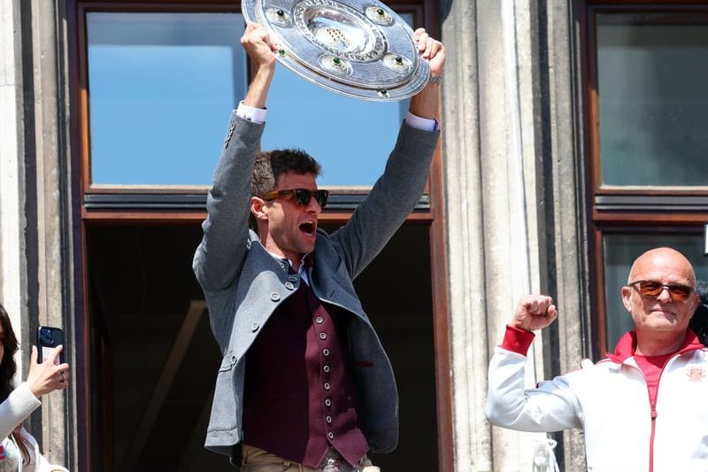 Meisterfeier der Fußballerinnen und Fußballer des FC Bayern München: Thomas Müller (M) jubelt mit der Meisterschale auf dem Rathaus-Balkon.