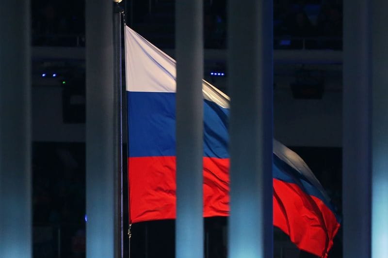 Eine Flagge Russlands weht hinter einem Zaun (Symbolbild).