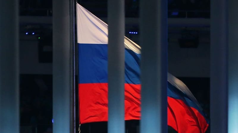 Eine Flagge Russlands weht hinter einem Zaun (Symbolbild).
