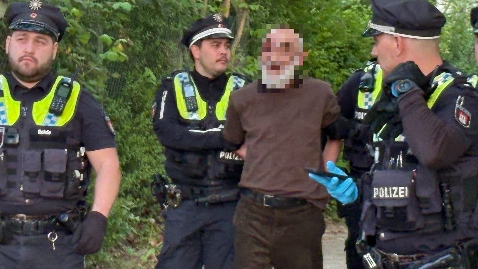 Polizisten führen einen Festgenommenen ab: Vermutlich ging es bei dem Streit um ein Päckchen Tabak.