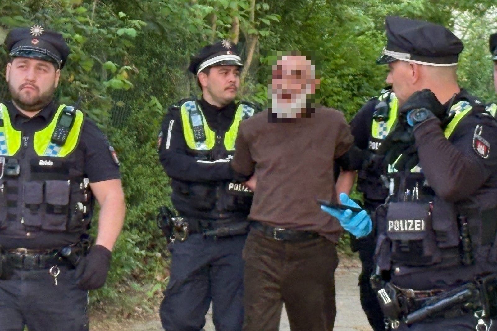 Polizisten führen einen Festgenommenen ab: Vermutlich ging es bei dem Streit um ein Päckchen Tabak.