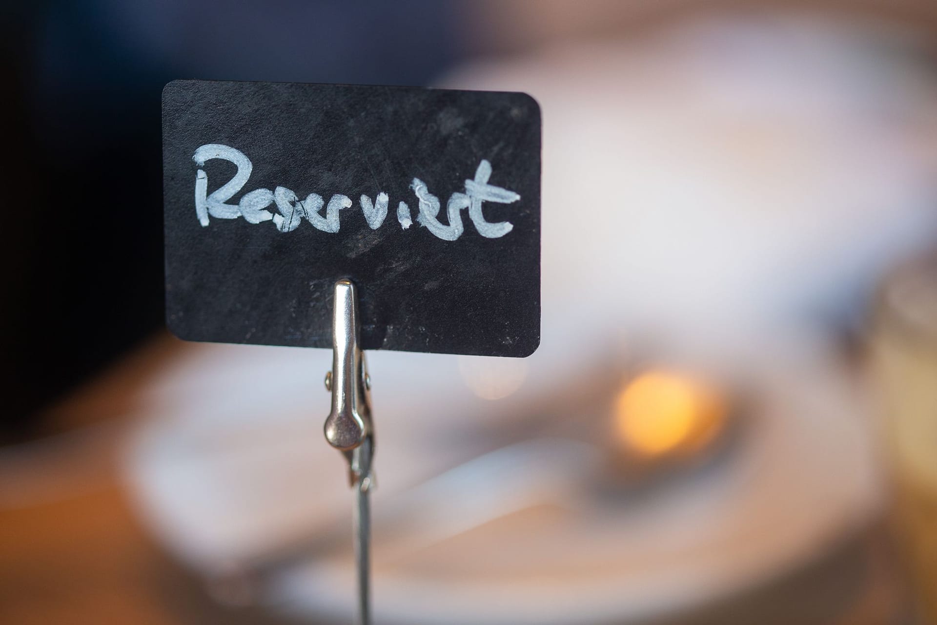 Ein Schild mit der Aufschrift «Reserviert» steht auf einem Tisch Ein Schild mit der Aufschrift «Reserviert» steht auf einem Tisch