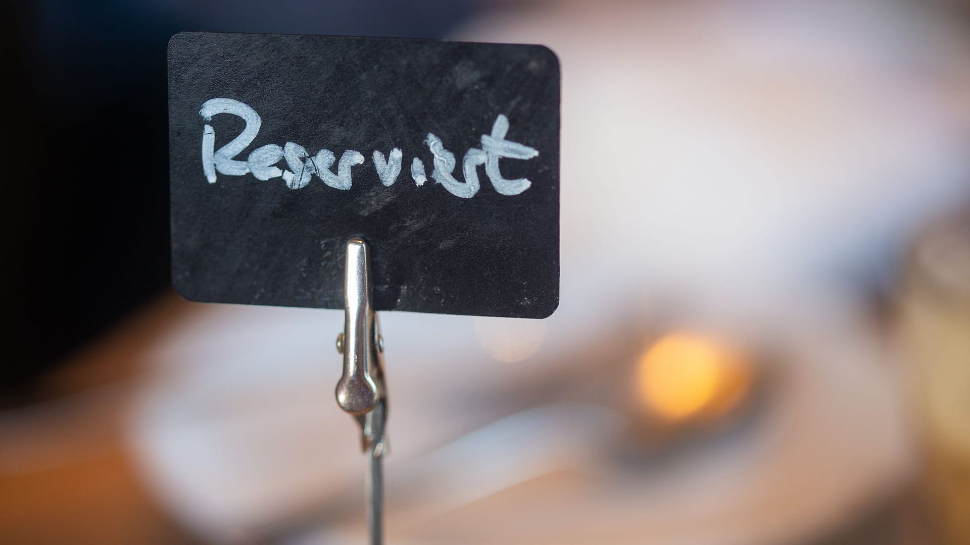 Ein Schild mit der Aufschrift «Reserviert» steht auf einem Tisch Ein Schild mit der Aufschrift «Reserviert» steht auf einem Tisch