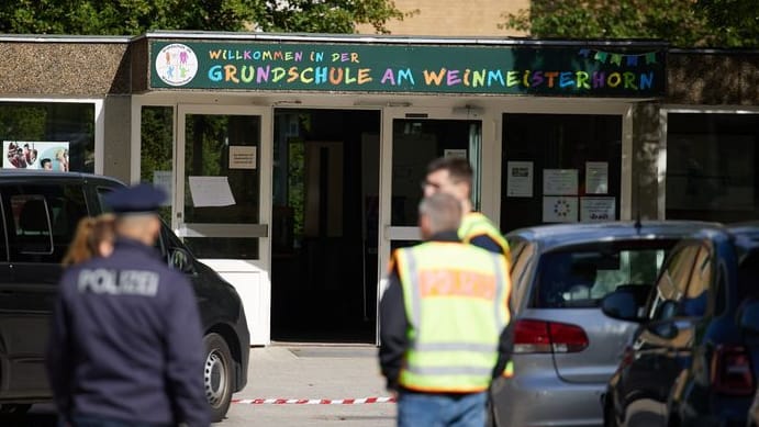 Polizisten stehen vor der Grundschule in Spandau: Aktuell wird der mutmaßliche Täter psychologisch betreut. Polizisten stehen vor der Grundschule in Spandau: Aktuell wird der mutmaßliche Täter psychologisch betreut.