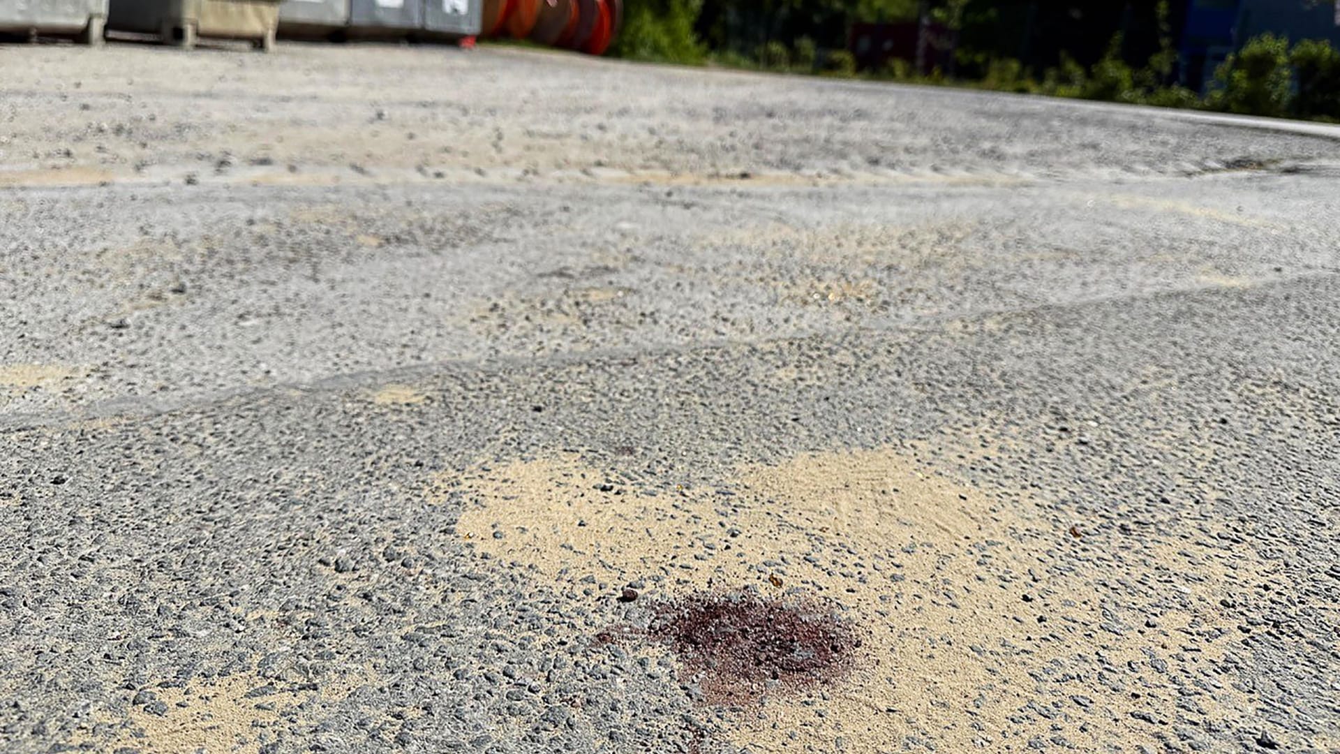 Menden: Ein Blutfleck ist auf dem Asphalt am Tatort in Menden im Sauerland zu sehen.