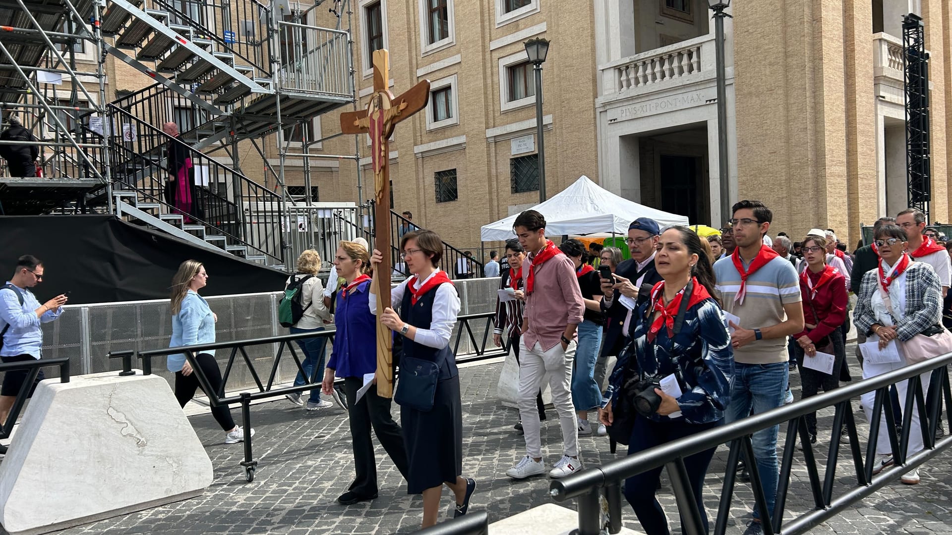 Menschengruppen mit einem Holzkreuz auf dem Petersplatz: Sie singen Kirchengesänge, während in der Sixtinischen Kapelle die Messe gefeiert wird.