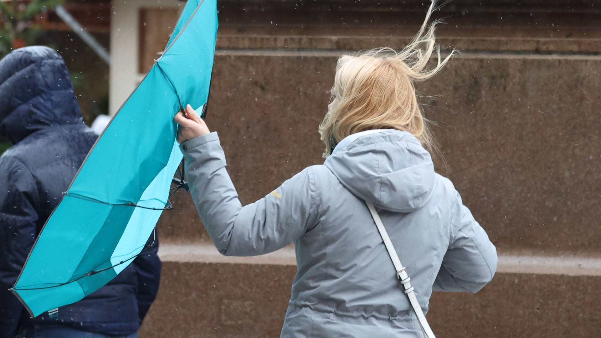 Frau mit Regenschirm im Wind (Archivbild): Ab Donnerstag muss in Hannover und Umgebung mit Sturmböen gerechnet werden.