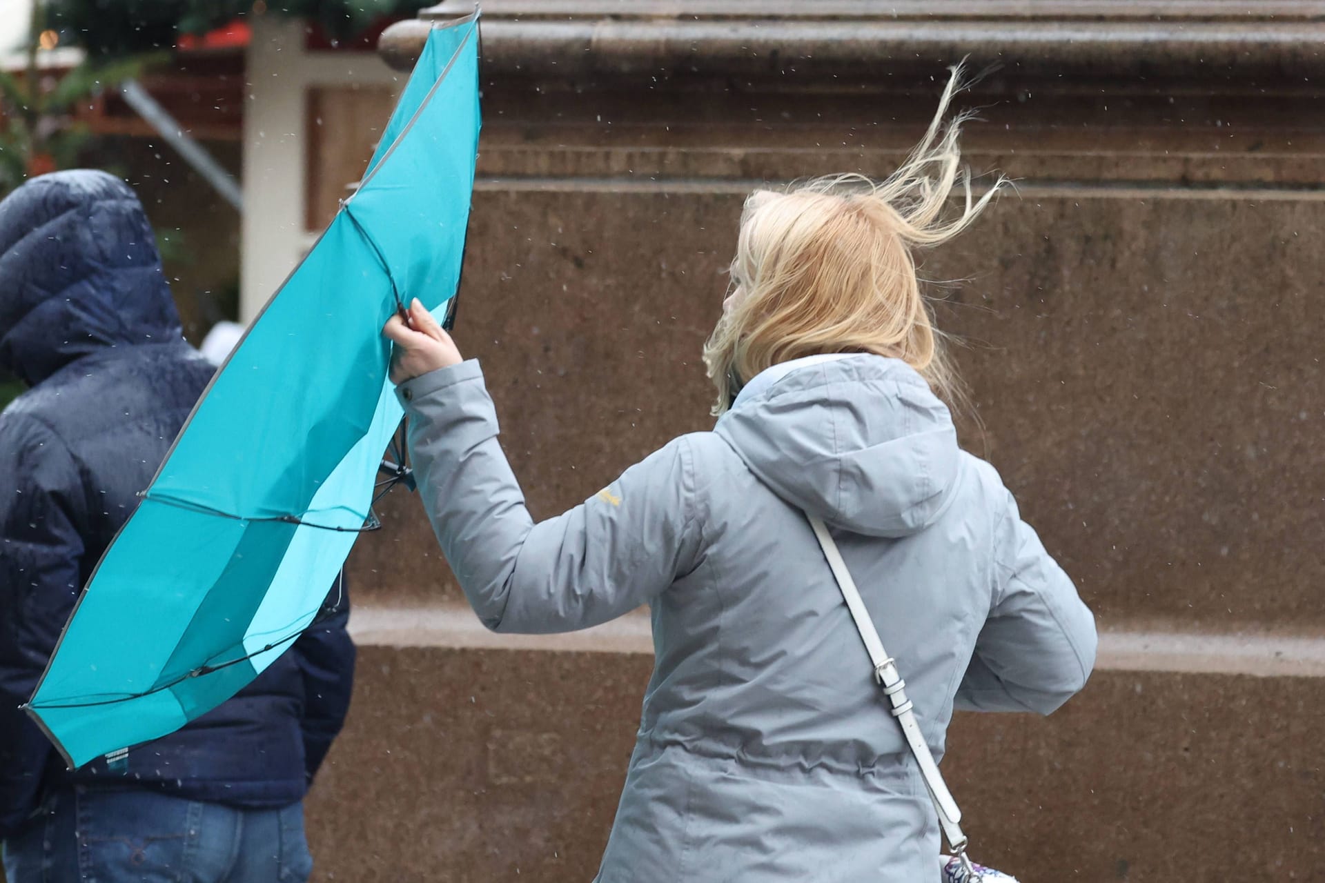 Frau mit Regenschirm im Wind (Archivbild): Ab Donnerstag muss in Hannover und Umgebung mit Sturmböen gerechnet werden.