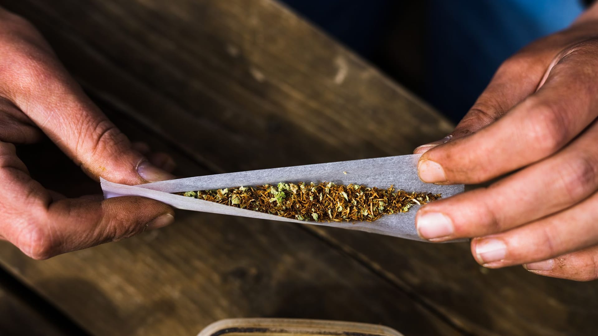 Mann dreht sich mit Cannabis und Tabak einen Joint Mann dreht sich mit Cannabis und Tabak einen Joint