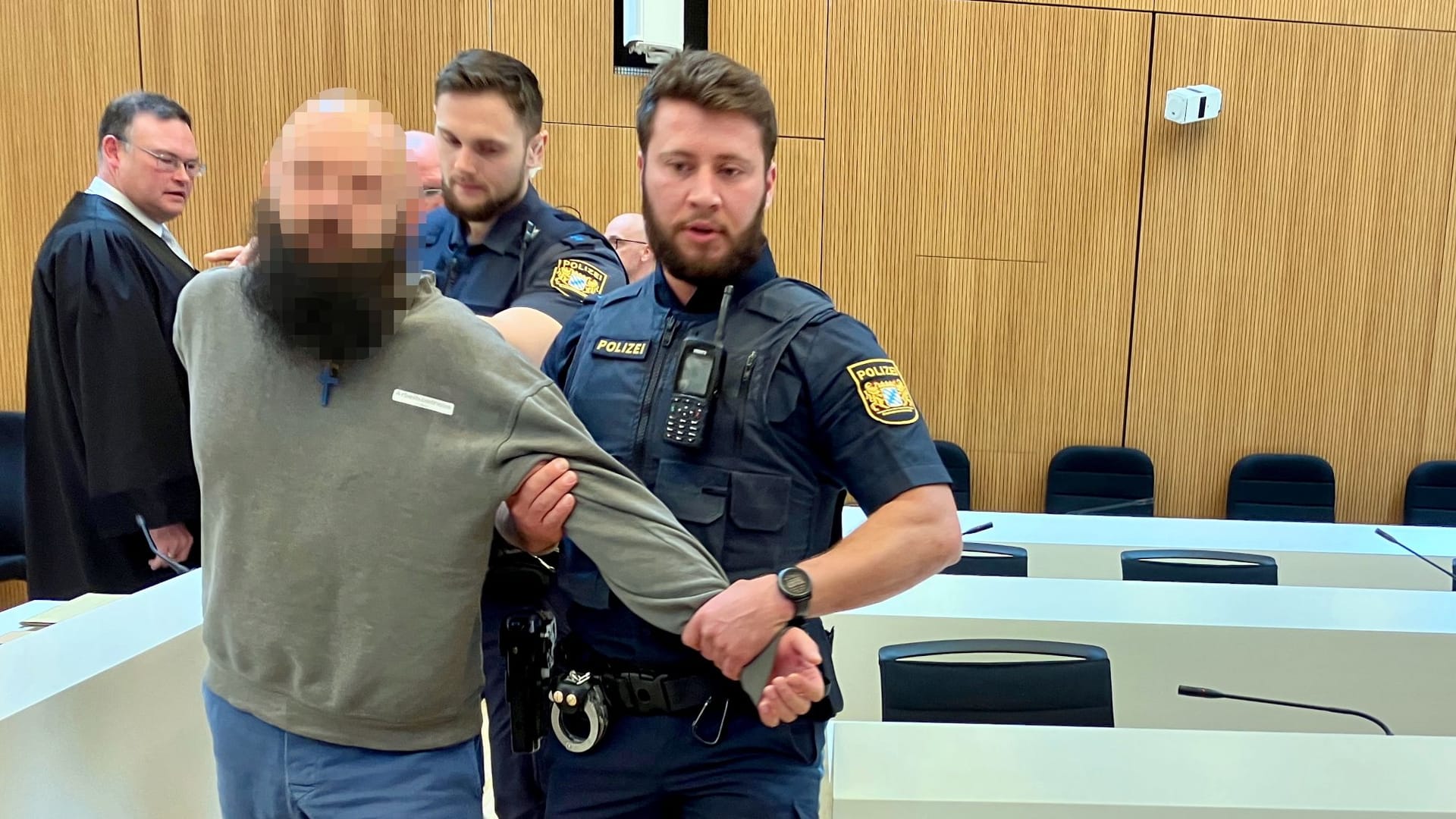 Dieter S. wird beim Prozessauftakt am Dienstagmorgen von Polizeibeamten in den Saal geführt.