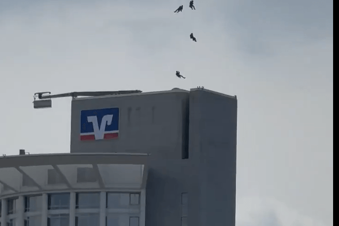 Ein Video in sozialen Medien zeigt die spektakuläre Aktion. Mehrere Beamte seilen sich aus einem Hubschrauber über dem Westend Tower ab.