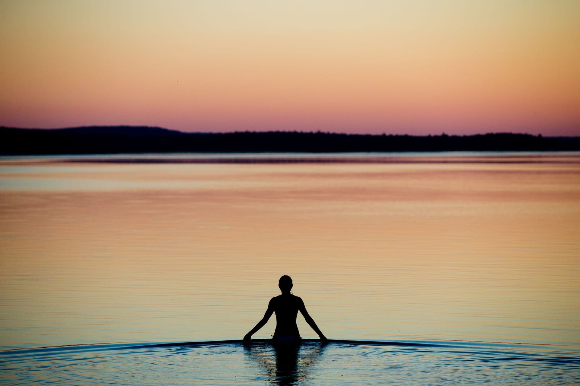 Frau badet an einem Sommerabend im Brombachsee