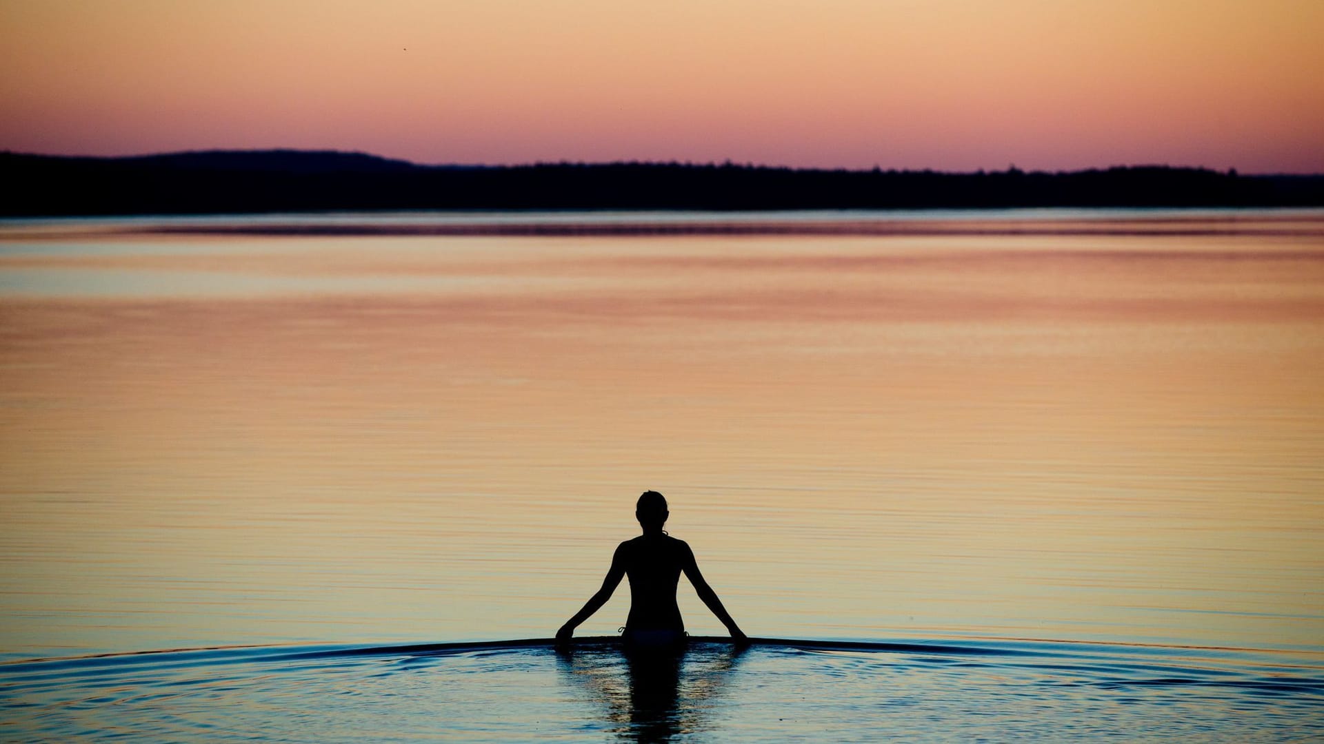 Frau badet an einem Sommerabend im Brombachsee Frau badet an einem Sommerabend im Brombachsee