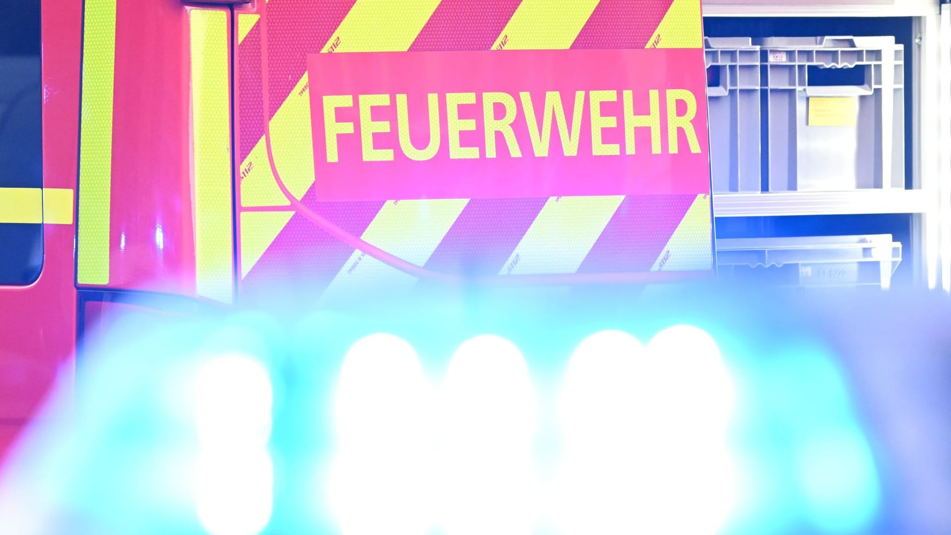ARCHIV - 02.05.2025, Baden-Württemberg, Stuttgart: Ein Fahrzeug der Feuerwehr steht bei einem Einsatz auf einer Straße, während im Vordergrund das Blaulicht eines Polizeifahrzeugs zu sehen ist. (zu dpa: «Bewohner bei Brand in Berlin-Mitte verletzt») Foto: Bernd Weißbrod/dpa