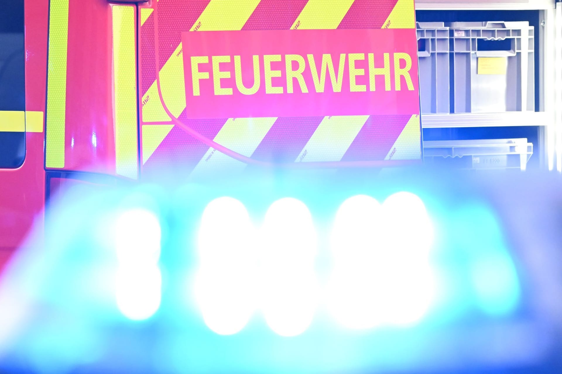 ARCHIV - 02.05.2025, Baden-Württemberg, Stuttgart: Ein Fahrzeug der Feuerwehr steht bei einem Einsatz auf einer Straße, während im Vordergrund das Blaulicht eines Polizeifahrzeugs zu sehen ist. (zu dpa: «Bewohner bei Brand in Berlin-Mitte verletzt») Foto: Bernd Weißbrod/dpa