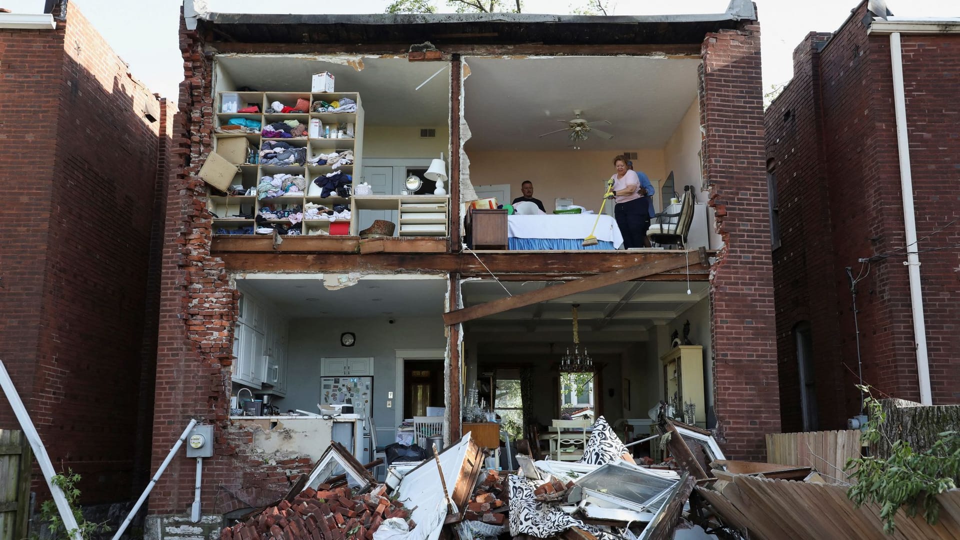 Bewohner inspizieren ihr Haus, nachdem ein Tornado die Rückwand eines zweistöckigen Hauses in St. Louis, Missouri, USA, vollständig abgerissen hat.