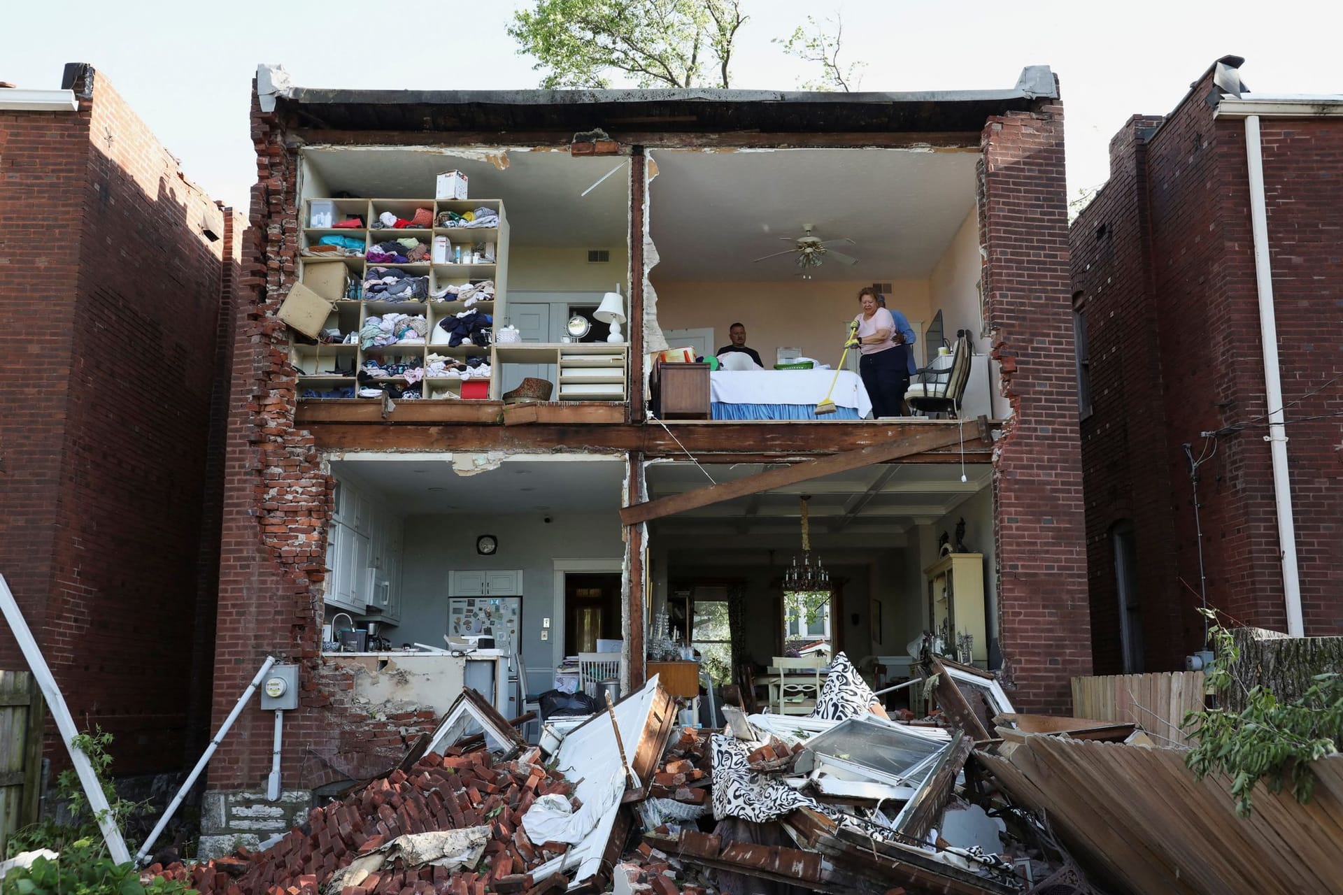 Bewohner inspizieren ihr Haus, nachdem ein Tornado die Rückwand eines zweistöckigen Hauses in St. Louis, Missouri, USA, vollständig abgerissen hat.