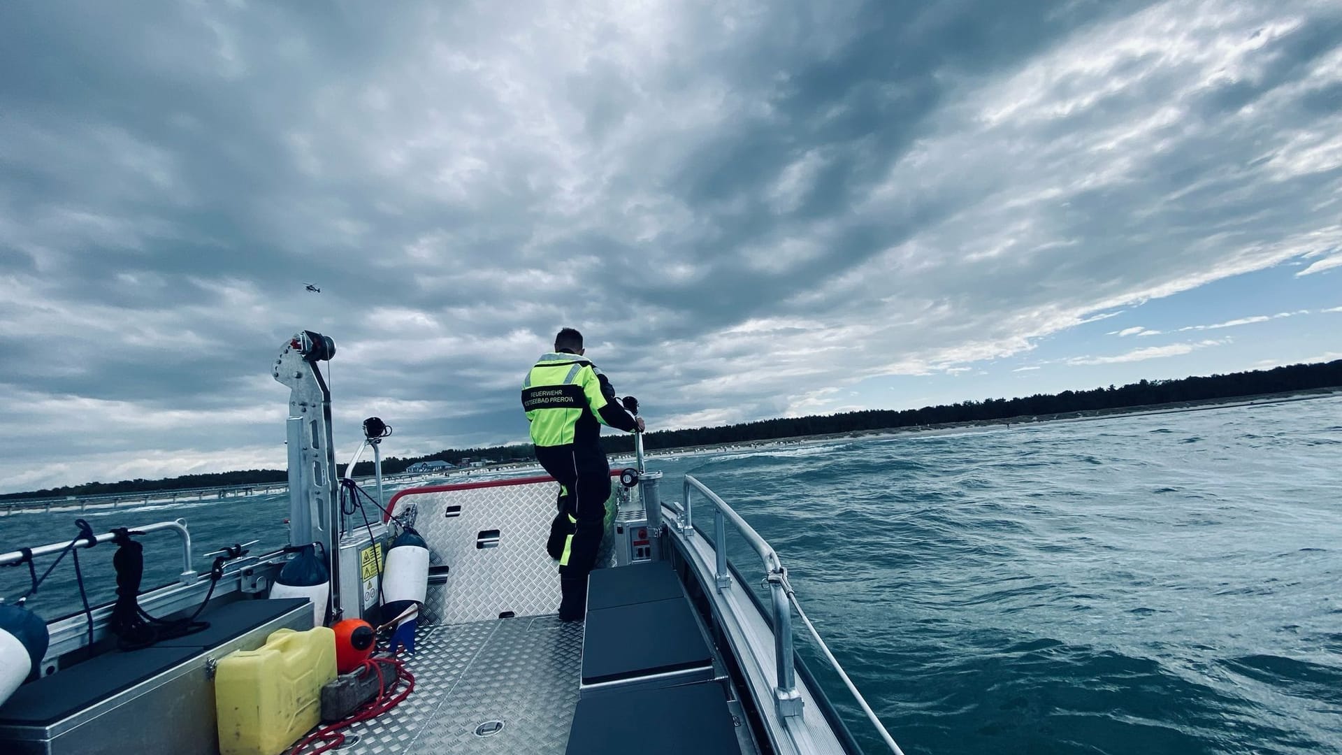 Ein Retter der Feuerwehr Prerow sucht mit einem Spezialboot nach dem verschwundenen Mann.