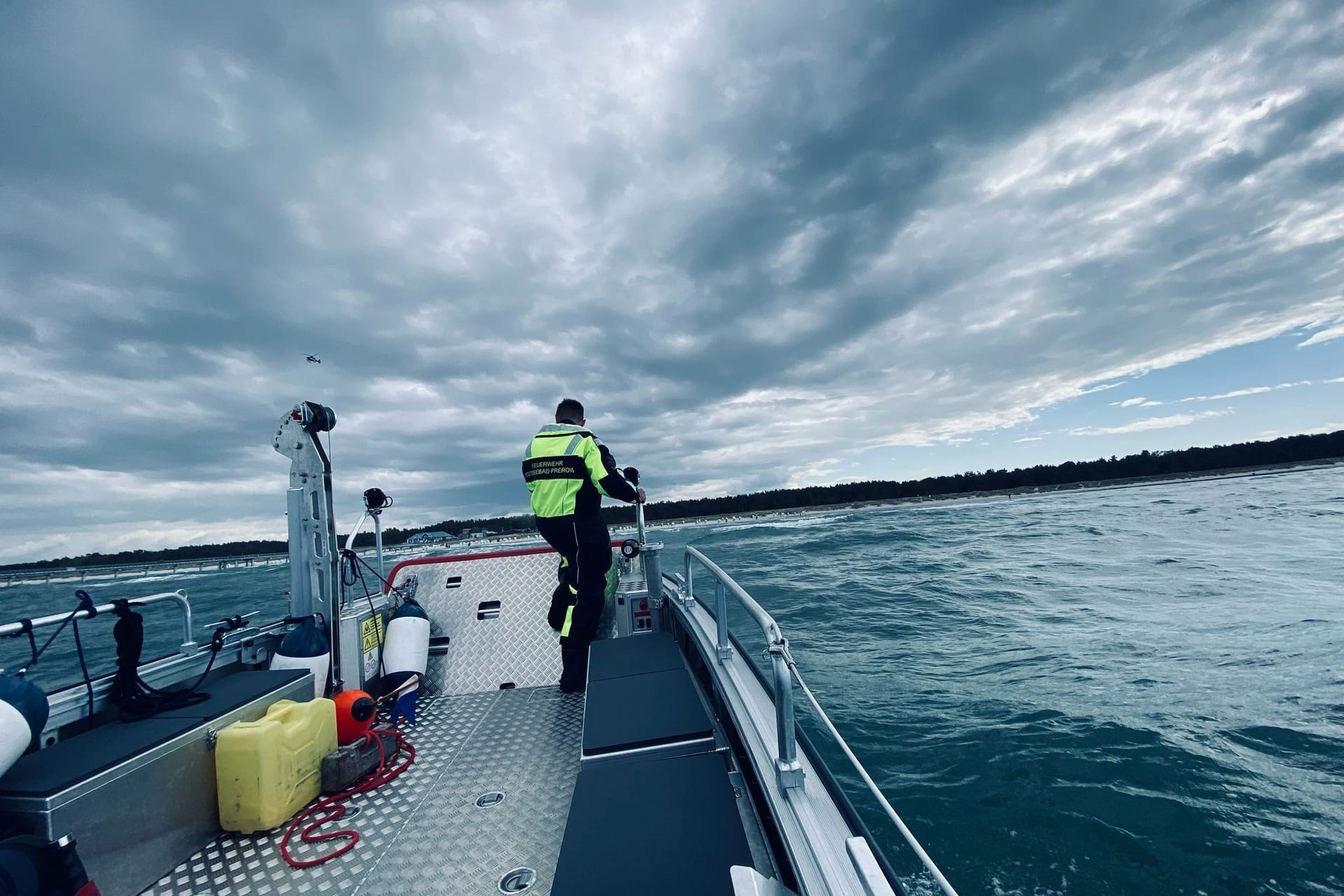 Ein Retter der Feuerwehr Prerow sucht mit einem Spezialboot nach dem verschwundenen Mann.