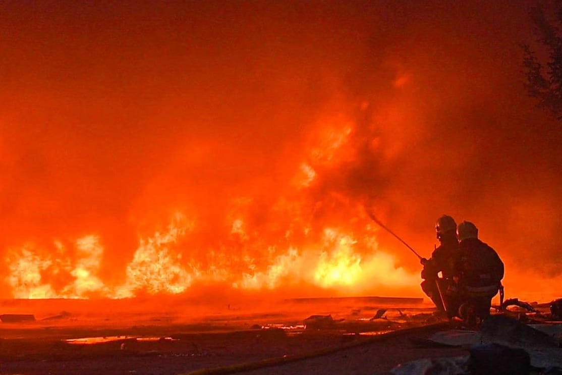 Feuerwehrleute löschen einen durch russische Angriffe ausgelösten Brand in der ukrainischen Stadt Sumy.