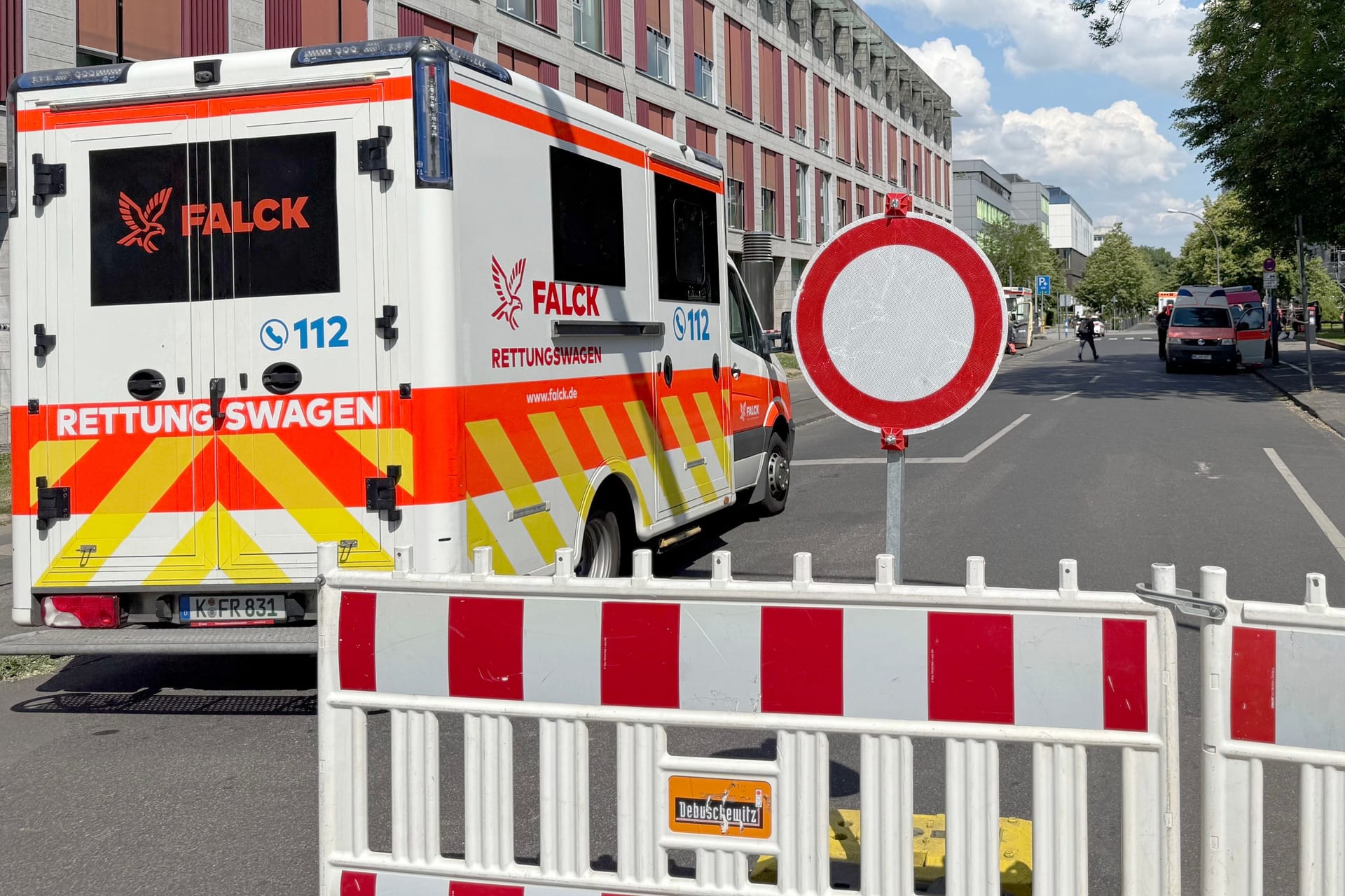An der Kölner Uniklinik ist das Gelände weiträumig abgesperrt: Krankenwagen, Ordnungsamt und Feuerwehr sind vor Ort, um bei der Bombenentschärfung zu unterstützen.