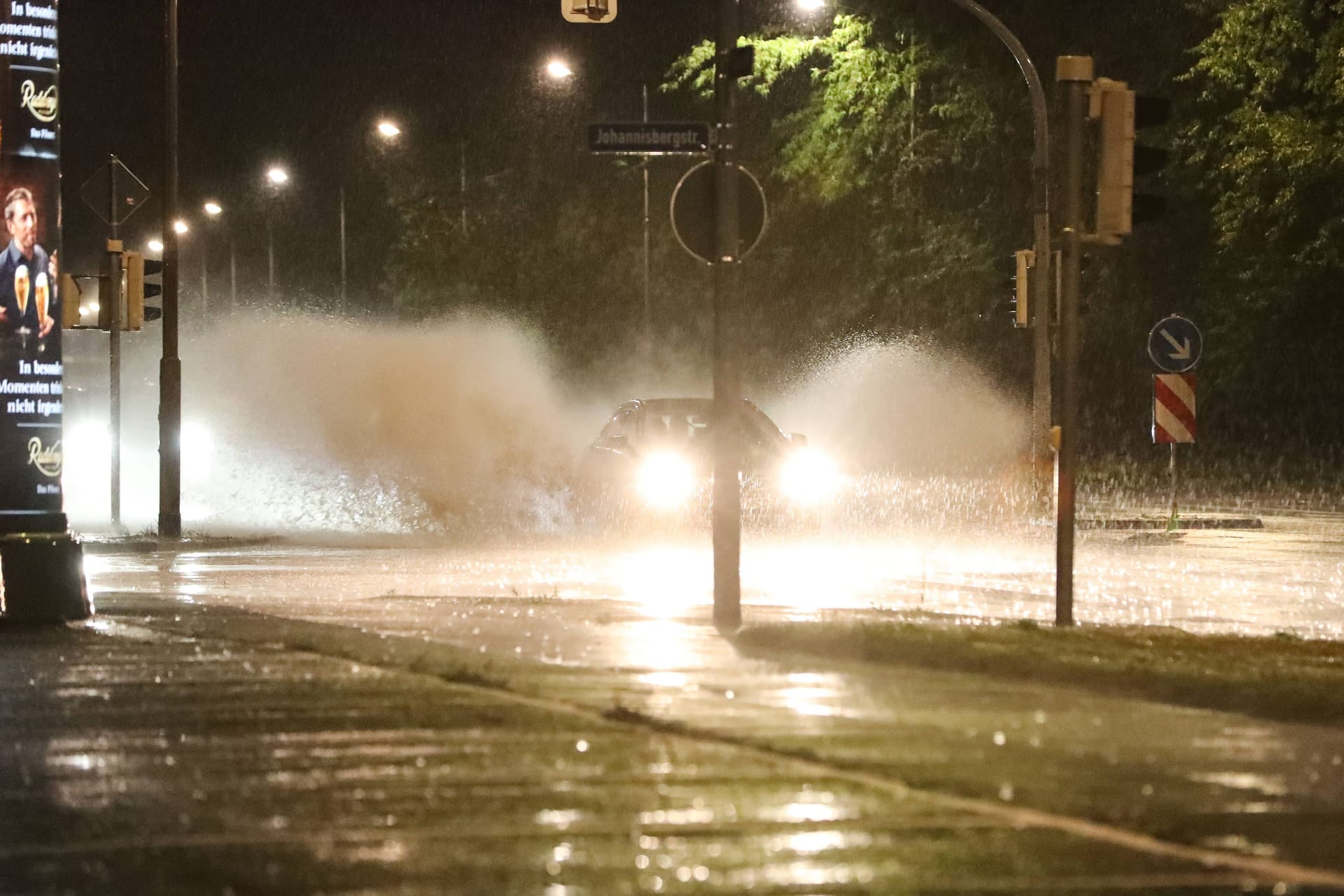 Ein Auto fährt durch eine Pfütze auf der Straße: In Sachsen kann es ungemütlich werden.