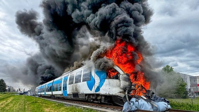 Der brennende Zug nach der Kollision mit einem Lkw: Alle Passagiere retteten sich nach draußen.