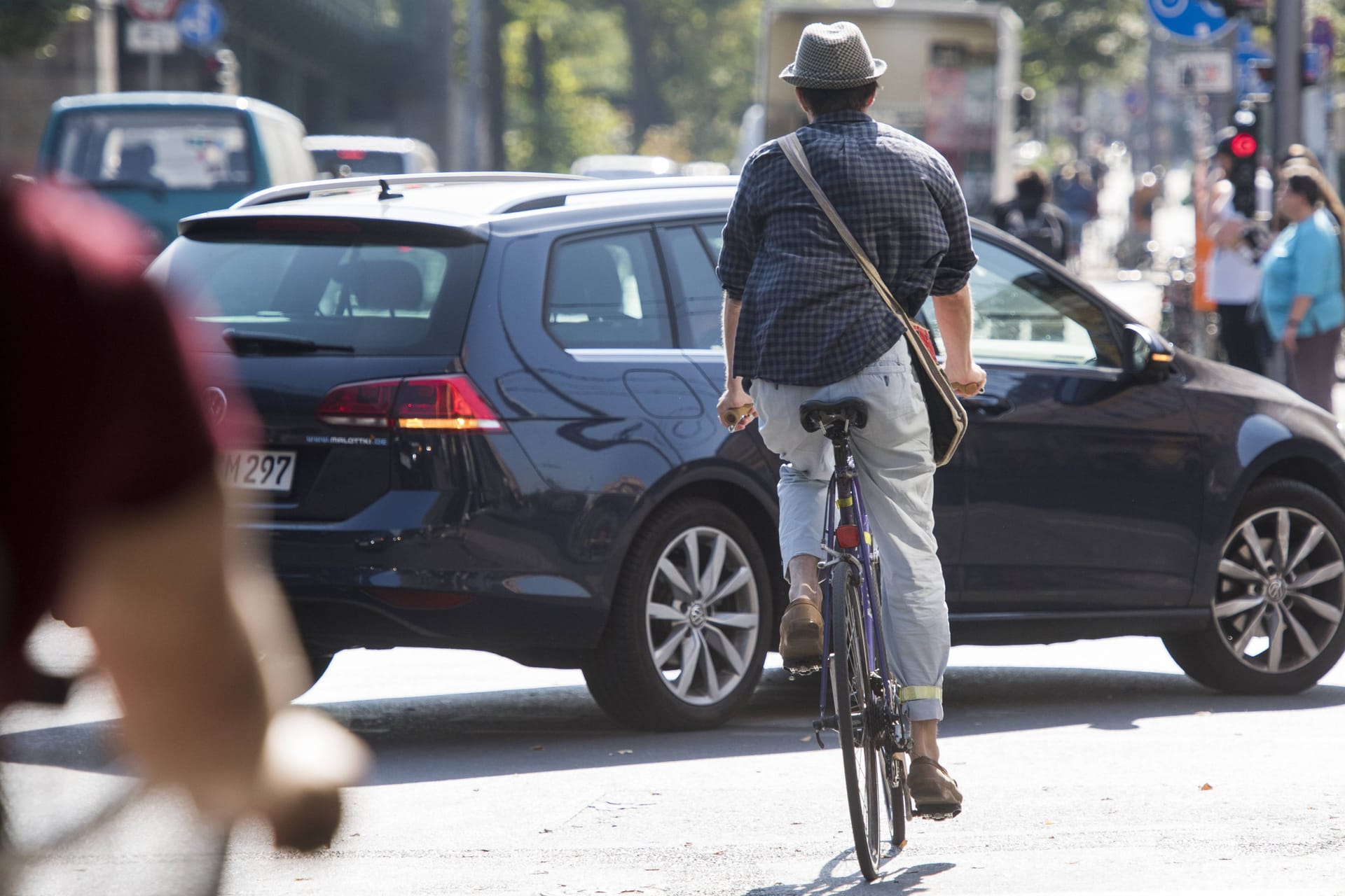 Ein Pkw behindert einen Radfahrer (Symbolbild): Häufig kommt es in Berlin zu Abbiegeunfällen.
