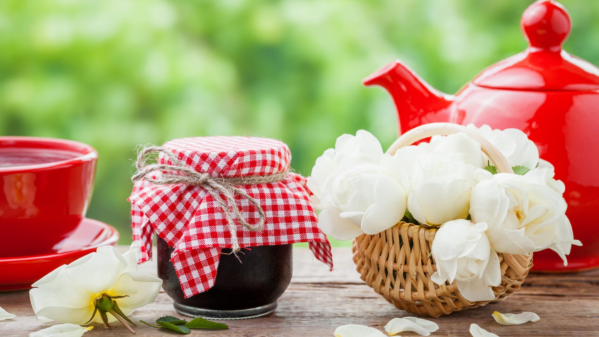 Red teapot, jars of jam, basket with roses bunch and tea cup. Red teapot, jars of jam, basket with roses bunch and tea cup.