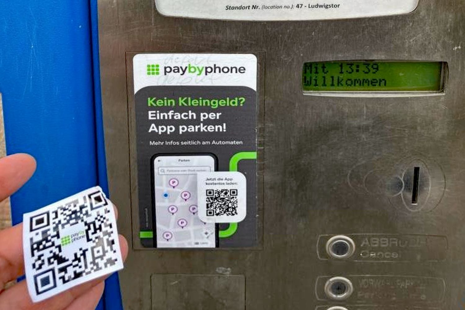 Ein QR-Code wird auf einen Parkautomaten geklebt: In Nürnberg tauchen immer mehr gefälschte QR-Codes auf.