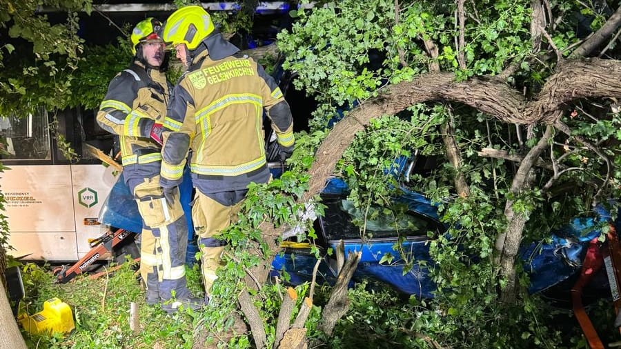 Einsatzkräfte an der Unfallstelle: Das Fahrzeug hatte sich zwischen Büschen und Bäumen verkeilt.