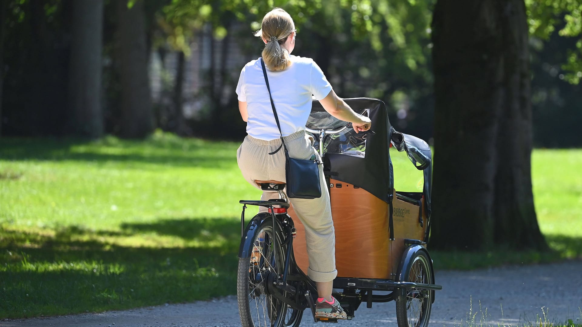 Frau mit Lastenrad fährt durch einen Park (Symbolbild): Mehrere Passanten kamen zur Hilfe.