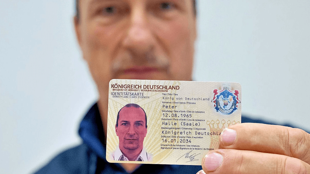 "König": Peter Fitzek mit einer Identitätskarte seines "Königreichs". Der Bundesinnenminister hat die Vereinigung verboten.