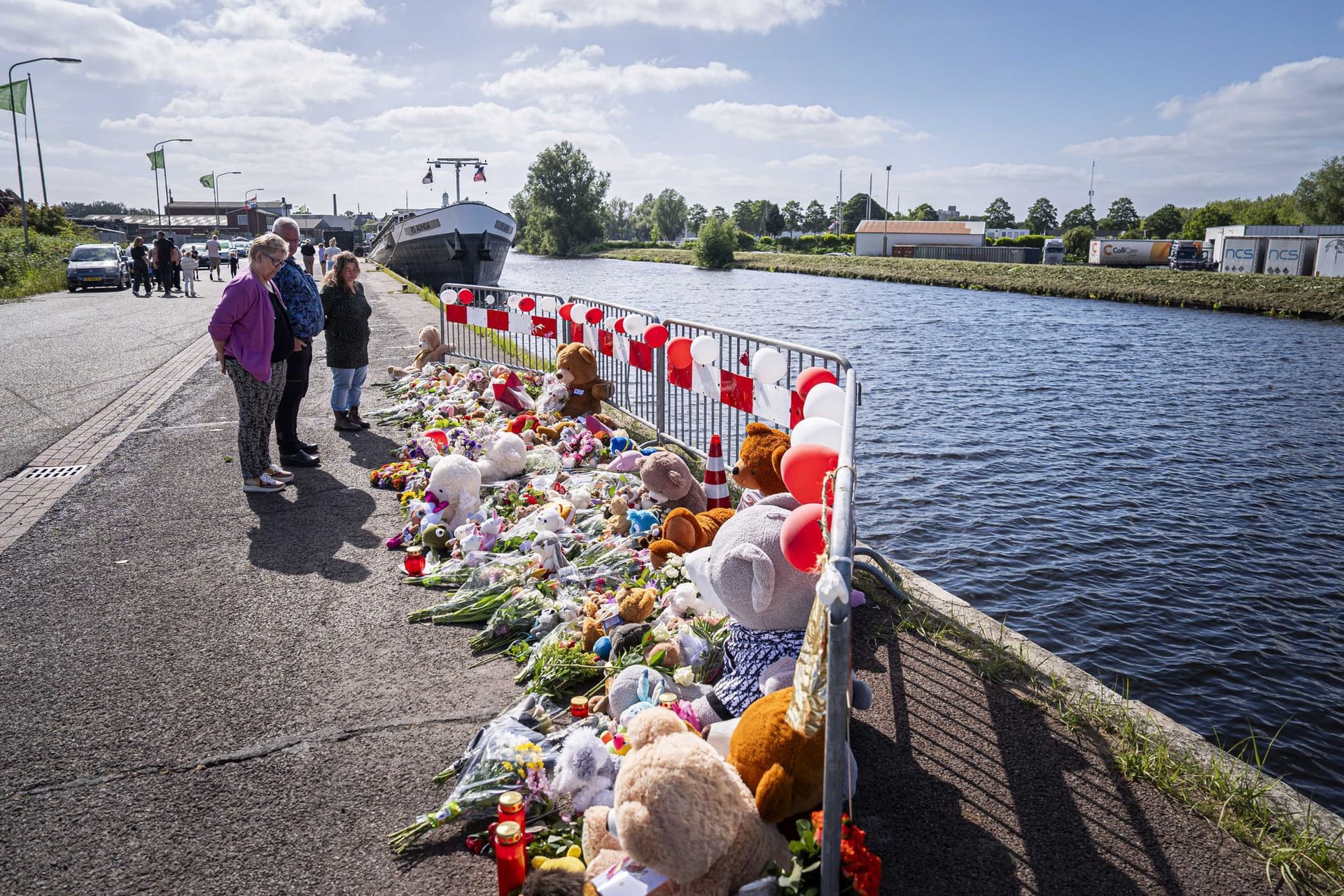 Menschen stehen an einer Gedenkstätte vor Blumen und Stofftieren: Nach tagelanger Suche sind die beiden vermissten Kinder tot aufgefunden worden.