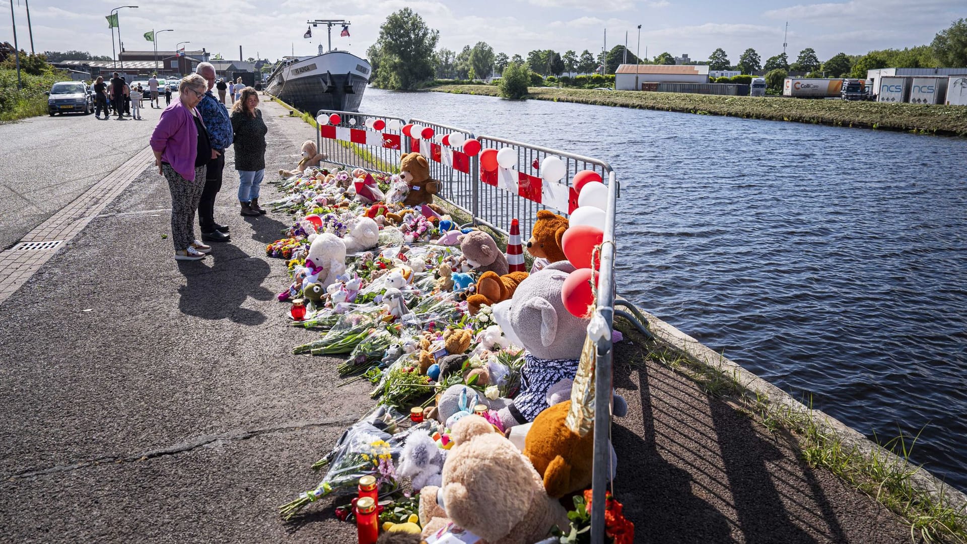 Menschen stehen an einer Gedenkstätte vor Blumen und Stofftieren: Nach tagelanger Suche sind die beiden vermissten Kinder tot aufgefunden worden.