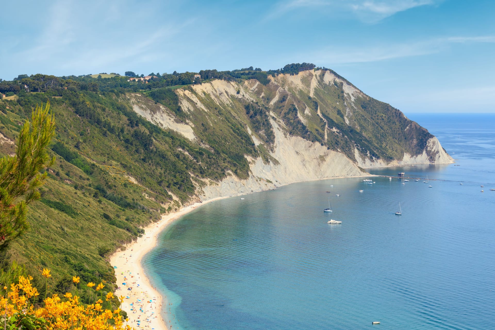 Summer Adriatic sea bay and blossoming Spiaggia Mezzavalle beach near Portonovo and Ancona towns in the Marche region. Italy, Conero Riviera. People unrecognizable.