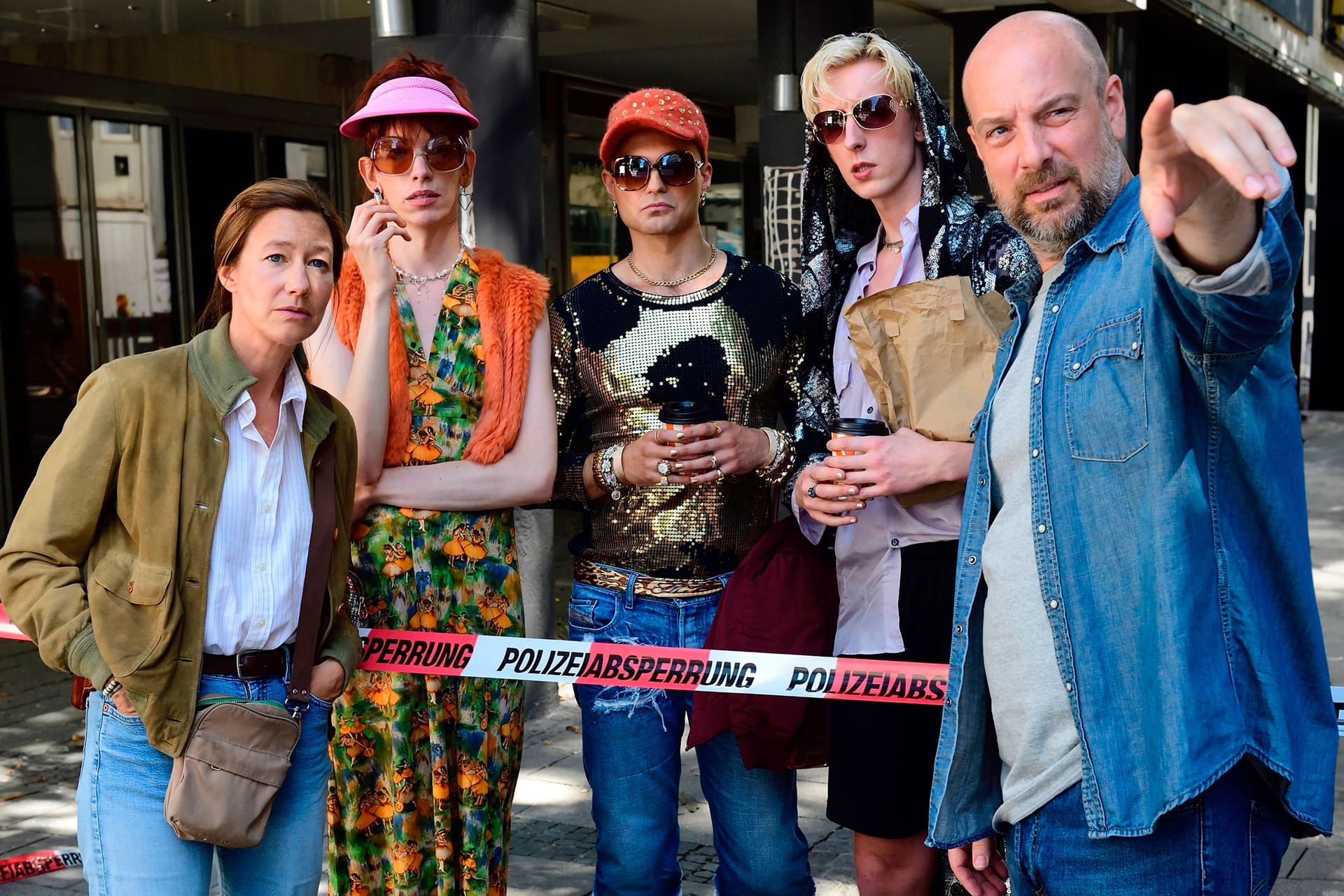 "Ein feiner Tag für den Bananenfisch": Schaulustige haben sich am Tatort versammelt. Darunter die Dragqueens.