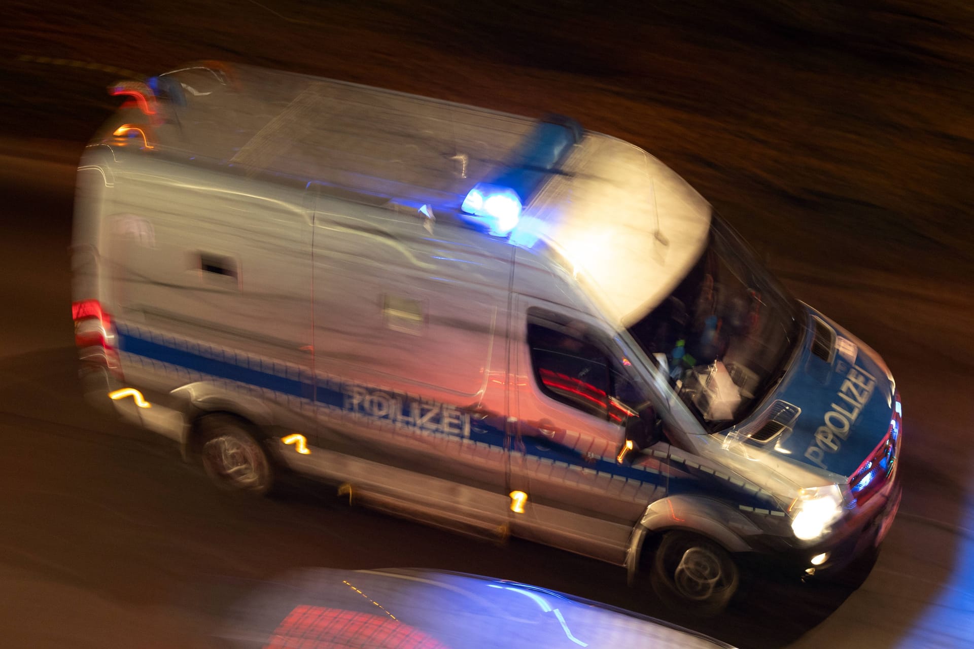 31.12.2024, Berlin, GER - Gefangenentransportwagen der Polizei bei Nacht auf Einsatzfahrt. Alltag, aussen, Aussenaufnahme, Berlin, Beruf, Bewegungsunschaerfe, Blaulicht, Blaulichtfahrt, deutsch, Deutschland, Draufsicht, Einsatz, Einsatzfahrt, Einsatzfahrzeug, Einsatzwagen, Europa, europaeisch, faehrt, fahren, fahrend, Fahrzeug, Gefangene, Gefangenenkraftwagen, Gefangenensammeltransport, Gefangenensammeltransporter, Gefangenentransportwagen, Gefangennahme, GefKw, Gesellschaft, gezoomt, Haft, Hilfe, innere Sicherheit, Jahreszeit, Job, KfZ, Kraftfahrzeug, Mannschaftswagen,