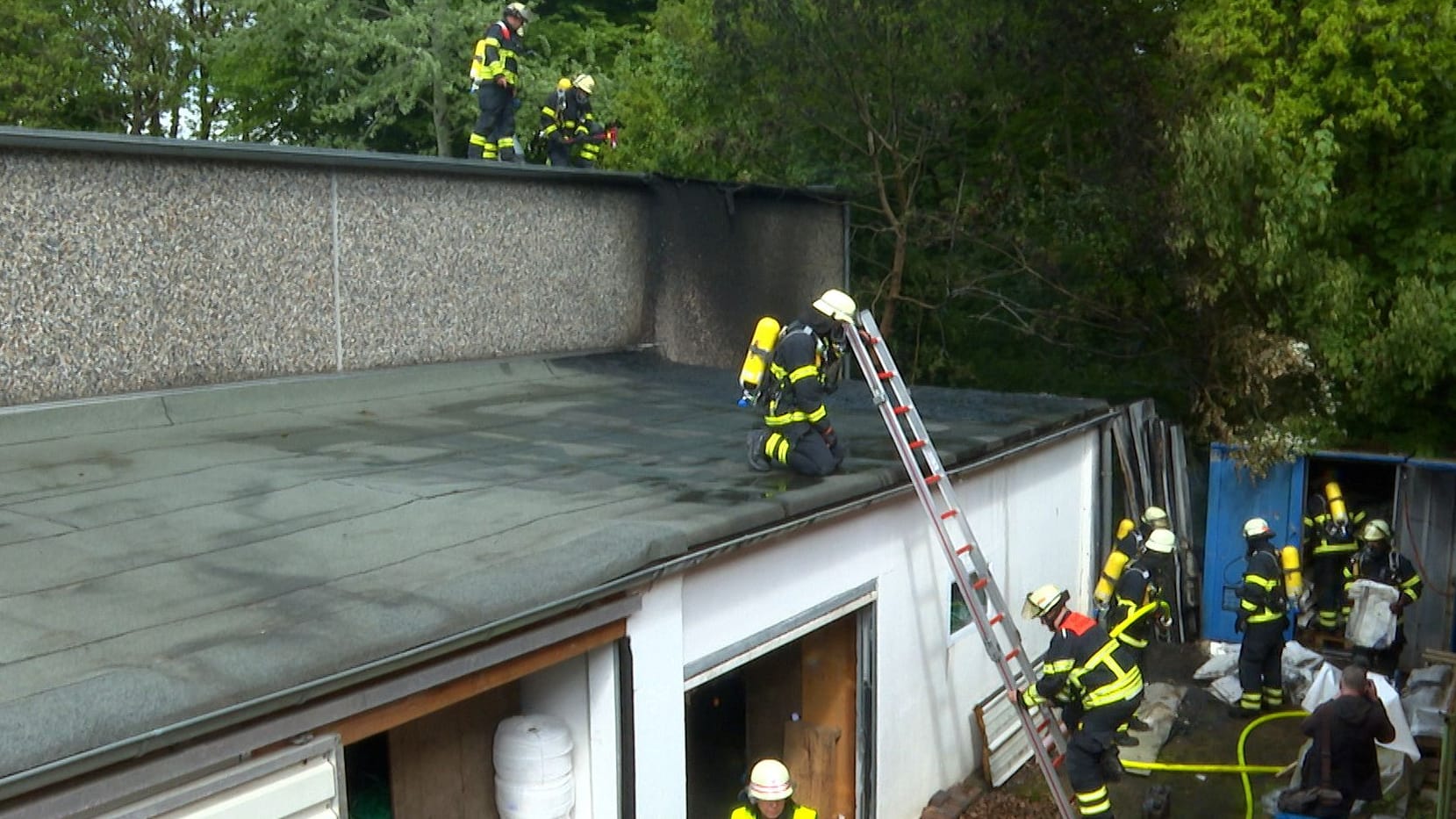 Die Feuerwehr löscht den Brand in Langenhorn: Das Feuer breitete sich bis auf das Dach einer Tischlerei aus. Die Feuerwehr löscht den Brand in Langenhorn: Das Feuer breitete sich bis auf das Dach einer Tischlerei aus.