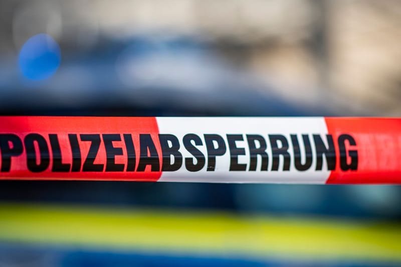Ein Absperrband mit der Aufschrift «Polizeiabsperrung» ist vor einem Polizeiwagen aufgespannt. (zu dpa: «Polizeieinsatz in Königs Wusterhausen»)